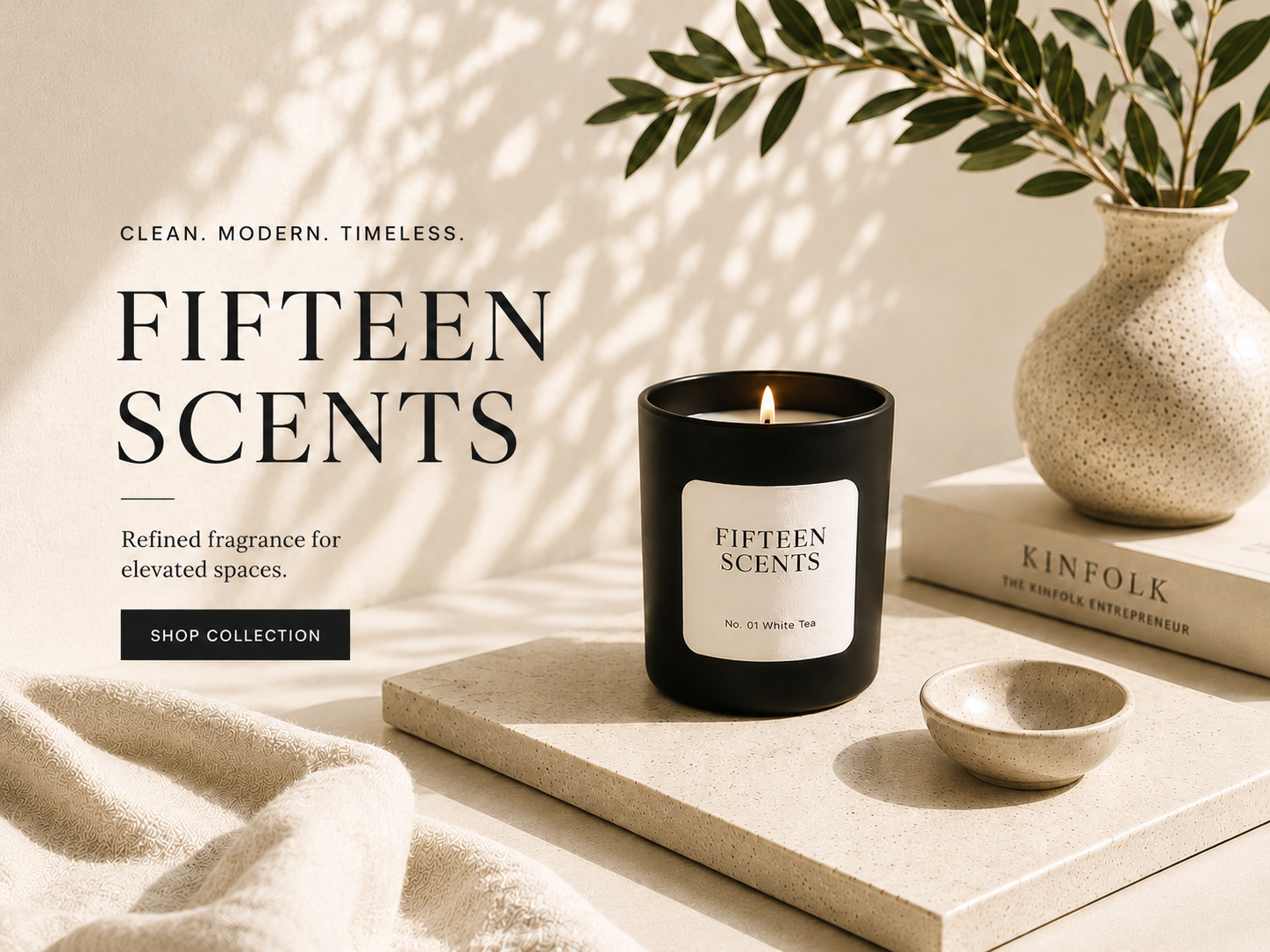 Fifteen Scents candle on a table with a vase and books in the background